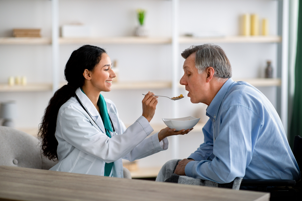 Healthcare professional assisting client with meal