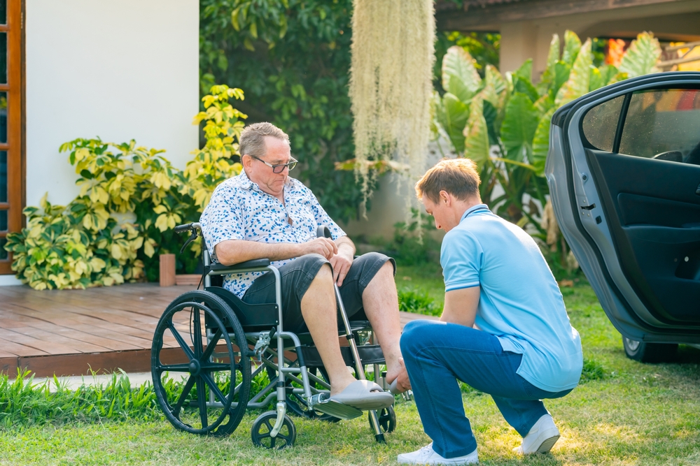 Caregiver assisting client from wheelchair to car